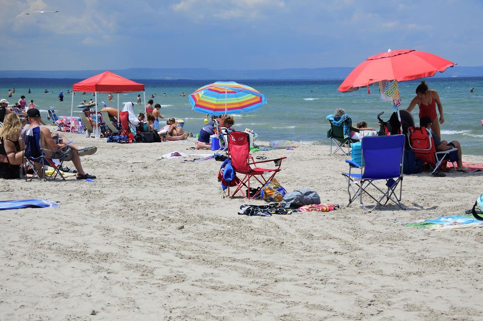 Beachgoers under colourful umbrellas on the sand at Wasaga Beach